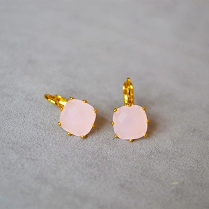 Vue macro de boucles d'oreilles en cristal rose taillé en coussin et or