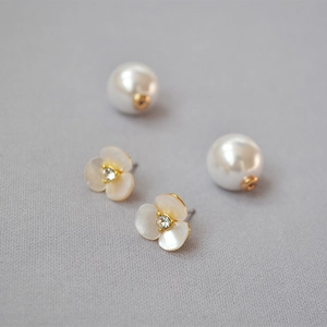 Detail of white mother-of-pearl clover earrings with central crystal and pearl backings