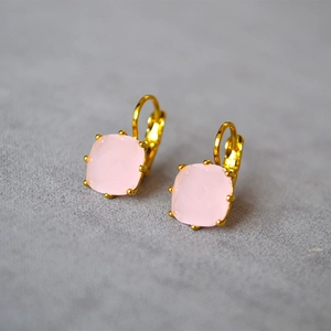 Détail des boucles d'oreilles avec gemme rose taille coussin et crochets français dorés