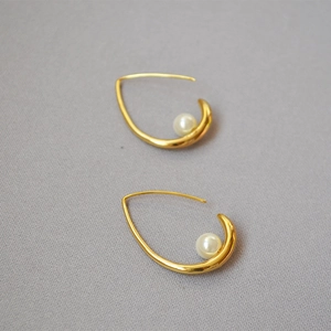 Elegant gold-tone curved hook earrings featuring teardrop faux pearl minimalist design