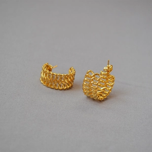 Detail of gold-plated woven chain hoop earrings with a textured hollow C-shape design