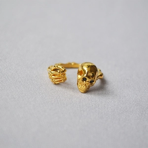 Macro detail of punk skull and claw open ring in 18K gold plated copper finish