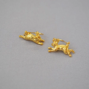 Detailed close-up of rabbit-shaped earrings with gold plating and engraved fur textures
