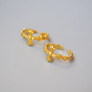 Close-up of golden gothic cross pattern rings with vintage matte metal finish