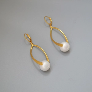 Detail of gold-plated leaf drop earrings with white pearls and lever-back hooks