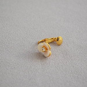 Detailed close-up of a white camellia flower ear clip with a sparkling central zircon