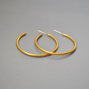 Minimalist matte gold brass C-shape hoop earrings with 925 silver needles on grey background
