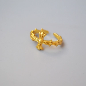 Macro shot of gold cross relief and vintage wavy texture on adjustable open ring