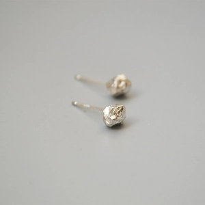 Detail showing irregular molten lava texture on silver stud earrings with 925 silver pins
