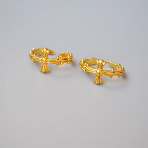 Detailed view of the vintage gold cross relief pattern on the adjustable metal ring band