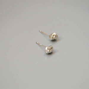 Detailed view of silver irregular lava rock textured studs with S925 silver needles