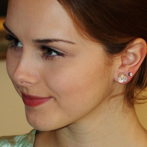 Elegant white mother of pearl clover earrings with small diamond center on model's ear