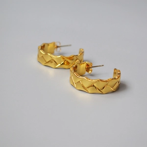 Macro shot of 18K gold plated hoop earrings featuring a classic quilted lattice texture
