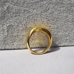 Makroaufnahme der polierten Goldbeschichtung und des modernen, gebogenen Ringbands