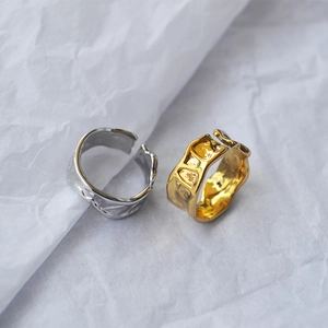 Details von unregelmäßigen Lavastrukturen auf gold- und silbernen verstellbaren Ringen