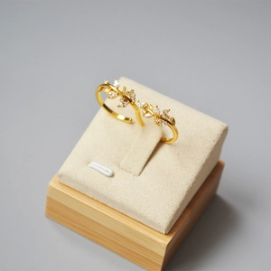 Elegant gold olive leaf ring with cubic zirconia stones on a professional display stand