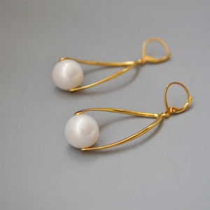 Elegant gold brass pearl drop earrings featuring minimalist curved lines and French hooks