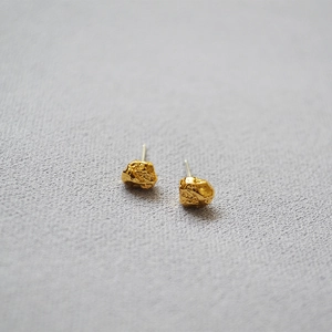 Close-up of golden irregular textured earrings showing the unique mineral rock surface