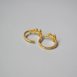 Macro shot of gold-plated olive leaf ring with cubic zirconia inlay details