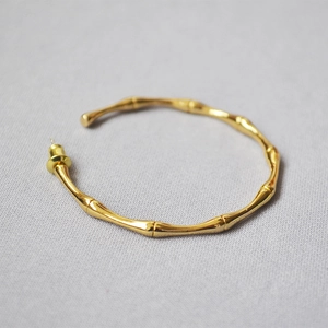 Minimalist bamboo hoop earrings in polished gold finish featuring a nature-inspired design
