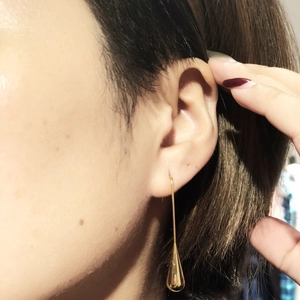 Elegant gold-plated waterdrop earrings featuring a sleek polished finish on model
