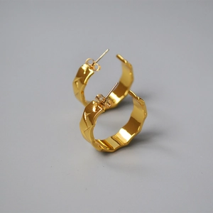 Detail of 18K gold plated hoop earrings with 3D diamond pattern and textured finish