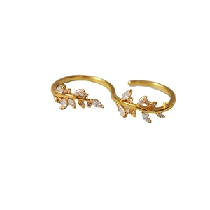 Elegant gold olive leaf double-finger ring with sparkling crystals on white background