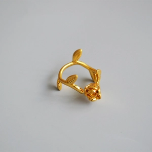 Detailed close-up of golden rose flower and leaf design on a brass adjustable ring