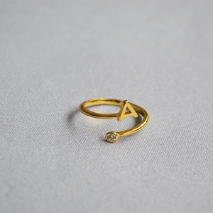 Macro detail of adjustable gold initial A ring featuring a sparkling cubic zirconia stone