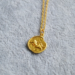 Vintage gold coin pendant necklace featuring an embossed portrait on a delicate chain