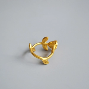 Close-up of matte gold rose bud and leaf details on vintage brass branch ring