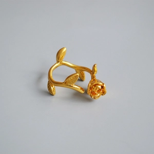 Macro detail of vintage gold-plated rose flower and vine textures on adjustable ring