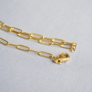Macro shot of 18K gold plated paperclip chain necklace with durable lobster clasp detail