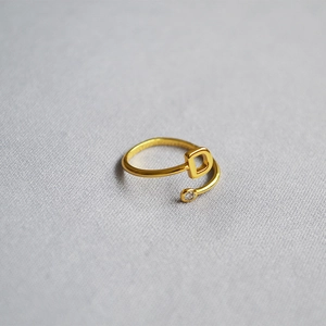 Detailed shot of golden adjustable ring featuring letter D and a sparkling zircon stone