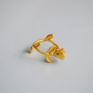 Detail view of gold vintage rose bud ring with textured vine band and delicate leaves