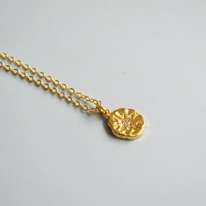 18K gold plated coin necklace featuring a hammered starburst pendant with shiny zircon