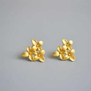 Vintage matte gold floral stud earrings featuring textured three-flower cluster design
