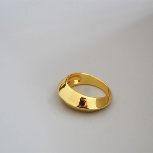 Polished brass wide curved ring in golden finish shown from a 45-degree angle