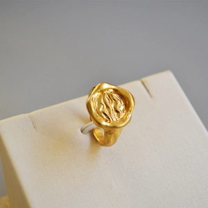 Vue macro détaillée de la texture organique irrégulière en or de cette bague en laiton