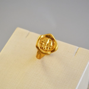 Gros plan d'une bague chevalière dorée avec une texture martelée irrégulière