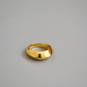 Macro shot of wide gold polished ring with minimalist geometric mirror finish