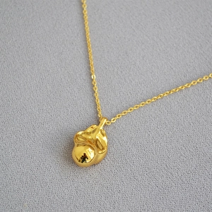 Detail of organic shaped gold-plated brass pendant on cross chain with freshwater pearl