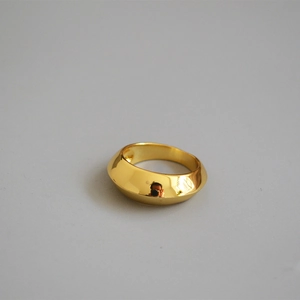 Macro detail of wide gold geometric ring featuring smooth mirror polished finish surface