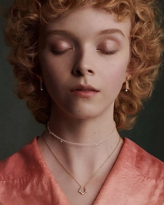 Elegant gold bow earrings and layered necklaces styled on a model with premium aesthetic
