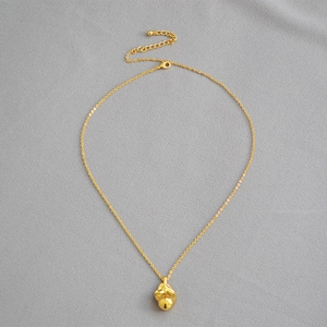 Detail of gold-plated brass necklace with fluid-shaped pendant and lobster clasp closure