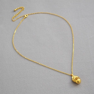 Macro shot of liquid metal style gold-plated pendant with polished link chain