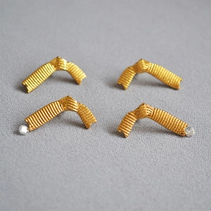 Polished 18K gold ribbon bow earrings with textured surface and sparkling rhinestones