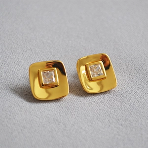 Close-up of square 18K gold plated earrings with sparkling zircon gemstone inlay