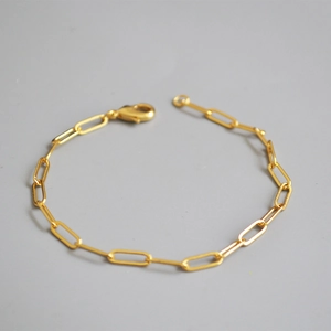 Close-up of gold-plated paperclip chain bracelet with a classic lobster clasp closure