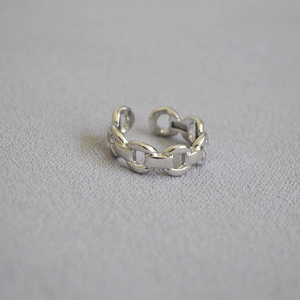 Détail d'une bague ouverte en chaîne gourmette argentée au design minimaliste ajustable